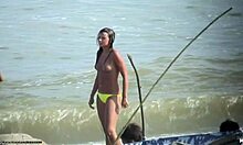 Topless bombshell showing her perky titties on a nudist beach